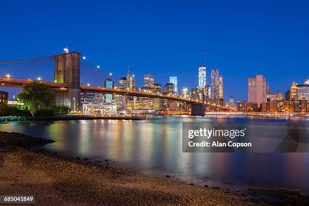 usa, new york, manhattan, brooklyn bridge over east river, lower manhattan skyline, including freedom tower of world trade center - alan copson stock pictures, royalty-free photos & images