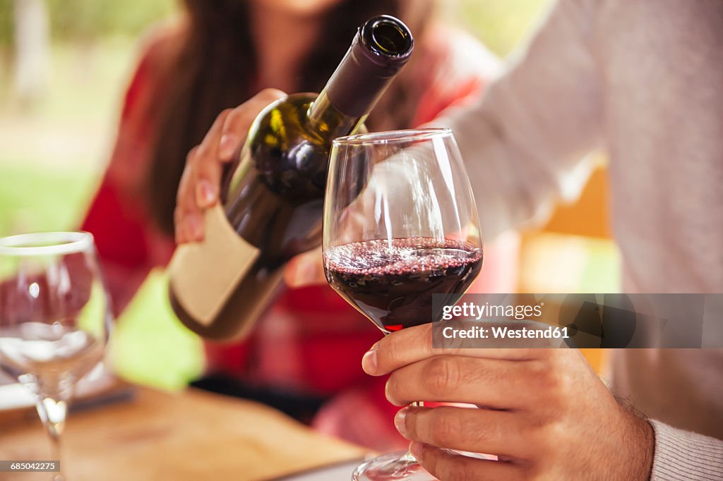 Man pouring red wine into glass