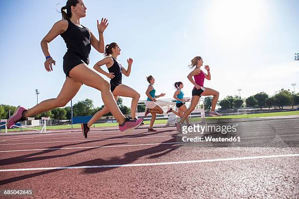 female runners on tartan track - leichtathletik stock-fotos und bilder