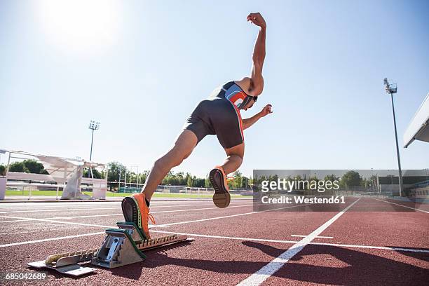 runner on tartan track starting - leichtathletik stock-fotos und bilder