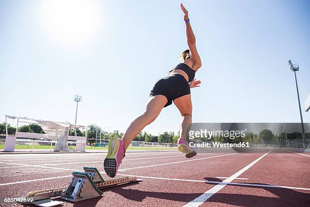 female runner on tartan track starting - track and field stadium stock pictures, royalty-free photos & images