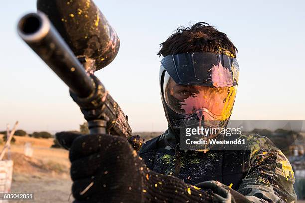 paintball player with paintball mask and paintball gun stained with paint - paintball stock pictures, royalty-free photos & images