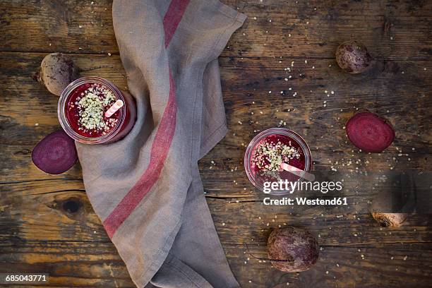 two glasses of beetroot smoothies with hemp seed and whole and sliced beetroots on dark wood - hemp seed 個照片及圖片檔