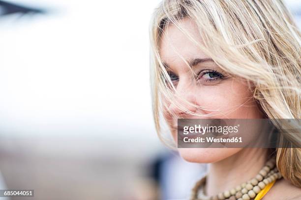 portrait of smiling blond woman - frau haarsträhne blond beauty stock-fotos und bilder