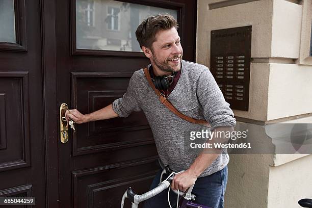 man with bicycle at front door - chegada imagens e fotografias de stock