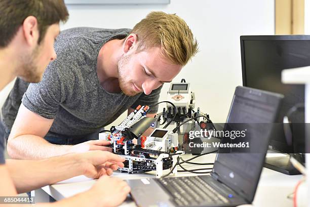 robotics students with laptop - mechatronics stockfoto's en -beelden