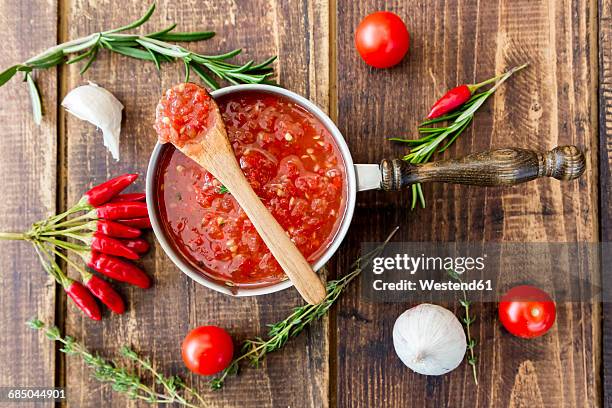 saucepan of homemade tomato sauce and ingredients on wood - kochlöffel stock-fotos und bilder