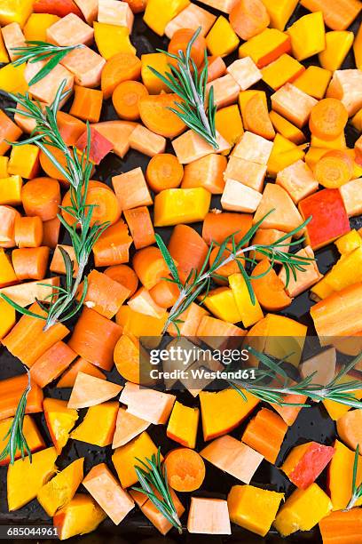 sliced pumpkin, carrots and sweet potatoes with twigs of rosemary on baking tray - sweet potato stock pictures, royalty-free photos & images