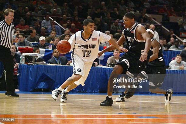 Kevin Braswell of the Georgetown Hoyas drives around Ryan Gomes of the Providence Friars during the first round of the Big East Tournament at Madison...