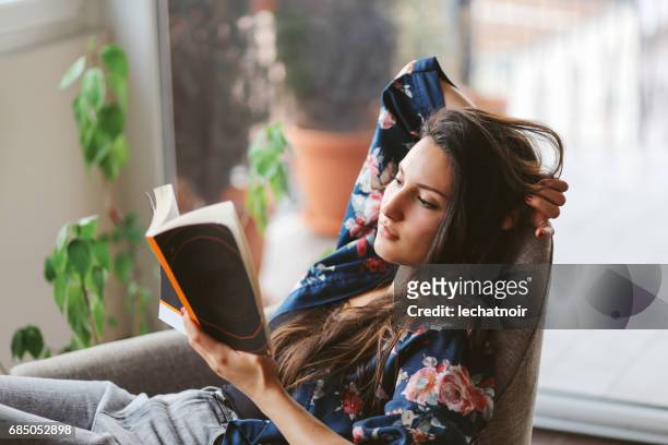 young woman reading at home - reading stock pictures, royalty-free photos & images