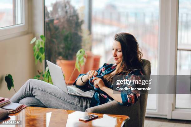 junge frau am laptop zu hause arbeiten - reading laptop pleased stock-fotos und bilder