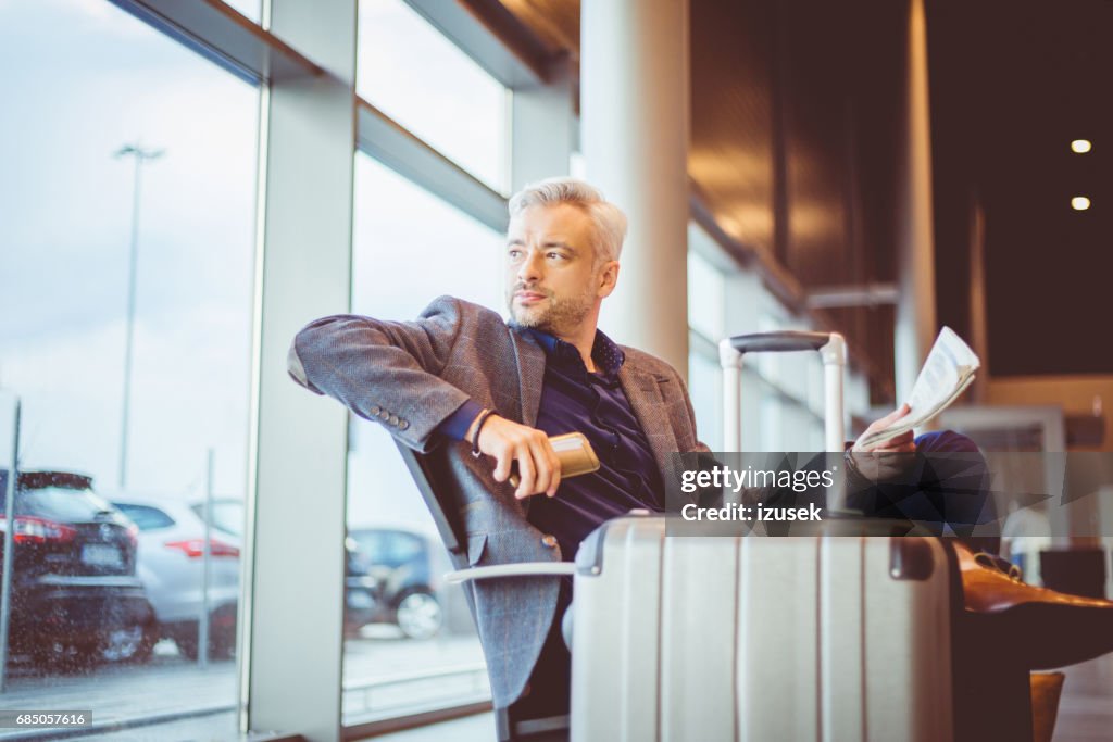 Rijpe zakenman te wachten op de luchthaven lounge