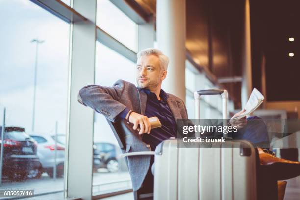 mature businessman waiting at airport lounge - business class lounge stock pictures, royalty-free photos & images