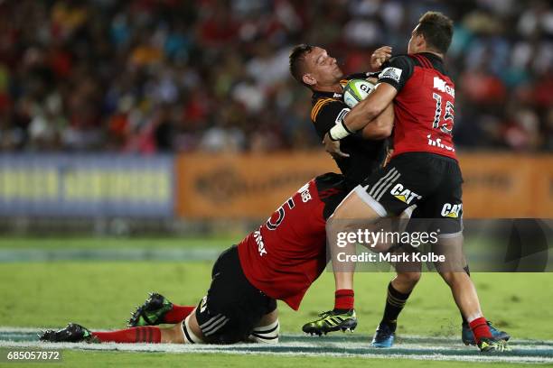 Aaron Cruden of the Chiefs is tackled by Sam Whitelock and David Kaetau Havili of the Crusaders during the round 13 Super Rugby match between the...