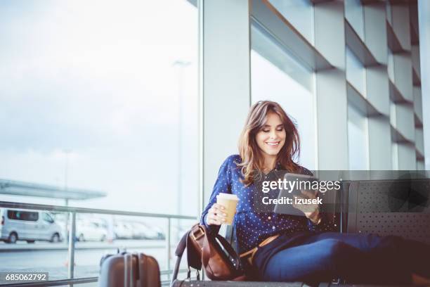 mujer pasajero espera su vuelo en el salón del aeropuerto - lector de libros electrónicos fotografías e imágenes de stock