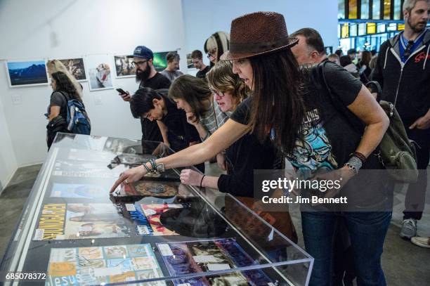 Fans read DJ comments written on vinyl records on display at a memorial for Chris Cornell held at radio station KEXP on May 18, 2017 in Seattle,...
