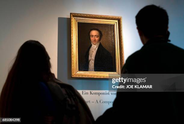Visitors look at a painting of the Austrian musician Franz Xaver Mozart at the Mozart Residence in Salzburg, as part of an exhibition organised by...