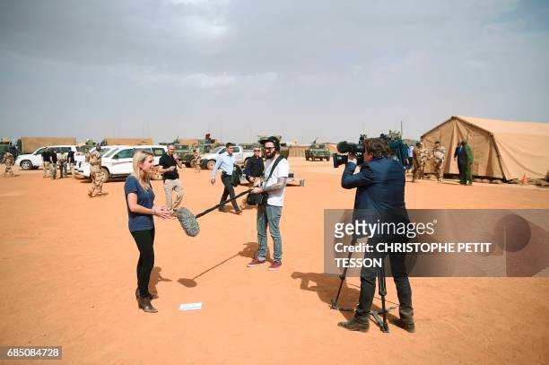 Journalists make live report prior to the visit of French President to the troops of France's Barkhane counter-terrorism operation in Africa's Sahel...
