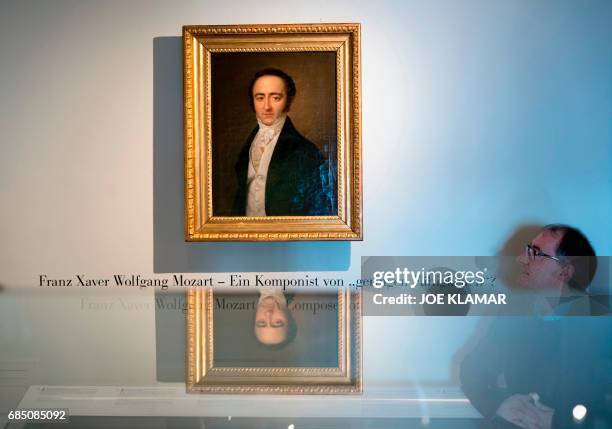 Curator Armin Brinzing looks at a painting of Austrian musician Franz Xaver Mozart on display at the Mozart Residence in Salzburg, during an...