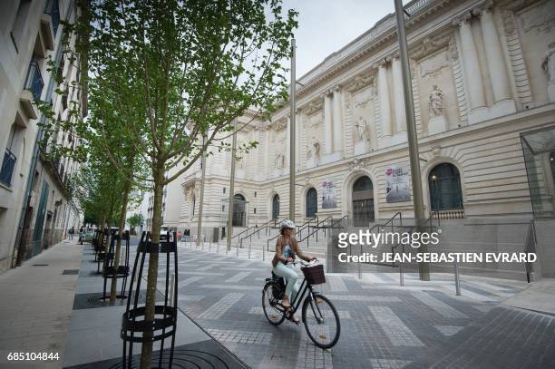 Woman rides a bike in front of the new Museum of Arts of Nantes, on May 17, 2017. More than 900 artworks need to be hang before the reopening of the...