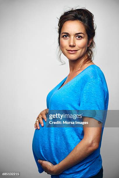 pregnant businesswoman with hands on stomach - family white background stock pictures, royalty-free photos & images