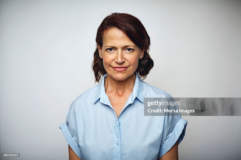 Confident businesswoman smiling over white