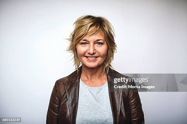 businesswoman wearing leather jacket over white - mujer 50 años fotografías e imágenes de stock