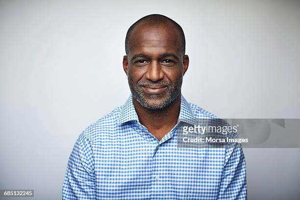 mature businessman smiling over white background - portrait stock-fotos und bilder