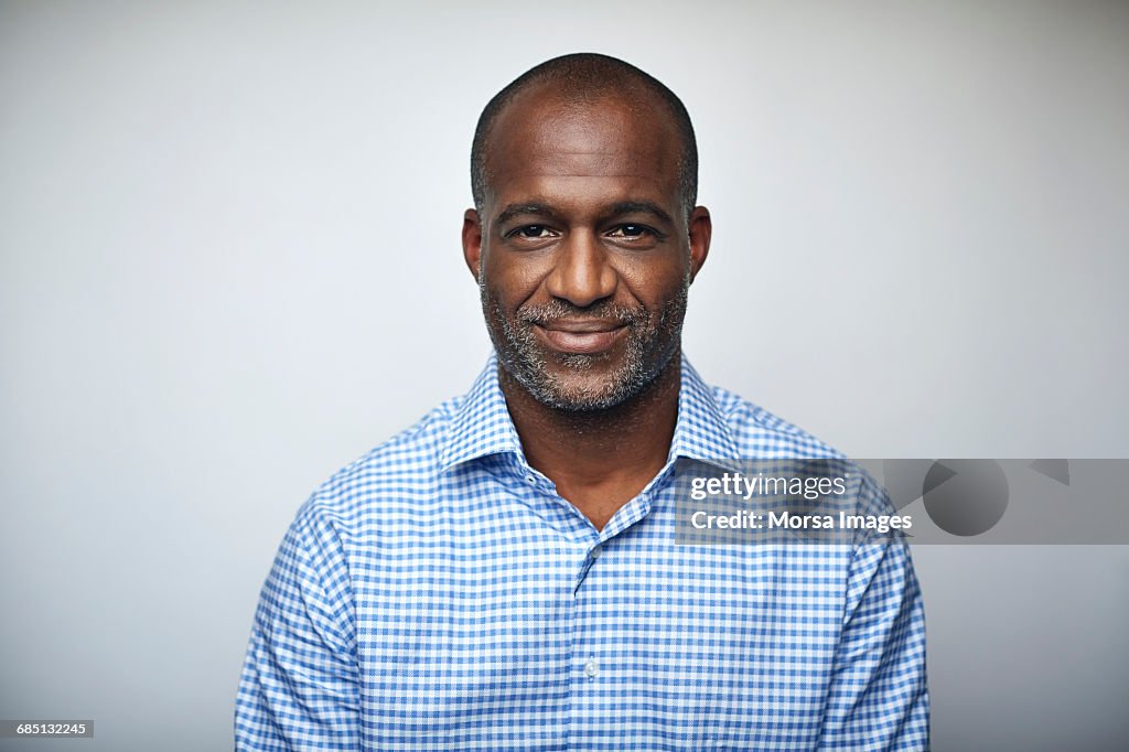 Mature businessman smiling over white background