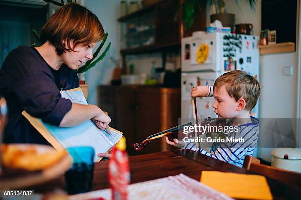 young boy using violin. - child musical instrument stock pictures, royalty-free photos & images
