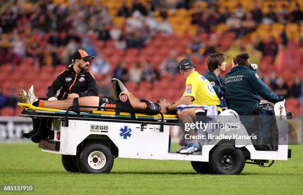 Josh Aloiai of the Tigers is taken from the field injured during the round 11 NRL match between the Brisbane Broncos and the Wests Tigers at Suncorp...