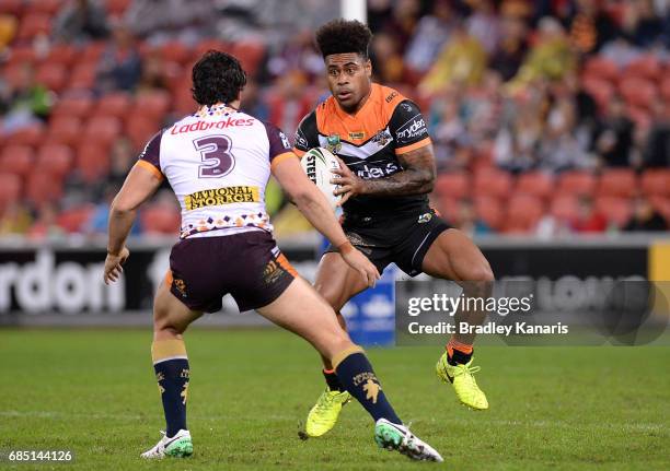 Kevin Naiqama of the Tigers takes on the defence of James Roberts of the Broncos during the round 11 NRL match between the Brisbane Broncos and the...