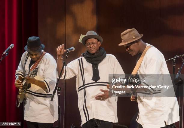 View of, from left, Aly Magassa, on guitar, bandleader Afel Bocoum, and Mamadou Kelly, on guitar, all of the Ali Farka Toure Band, as they perform...