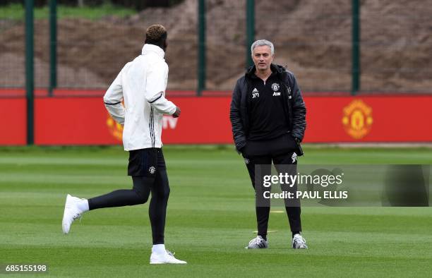 Manchester United's Portuguese manager Jose Mourinho chats to Manchester United's French midfielder Paul Pogba during a team training session as part...