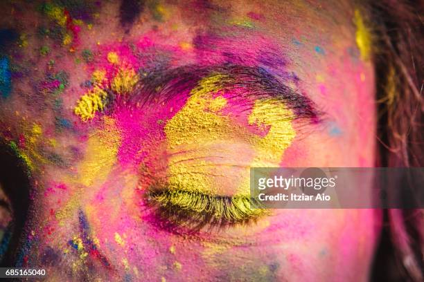 girl's face covered with holi colors - religion stock-fotos und bilder