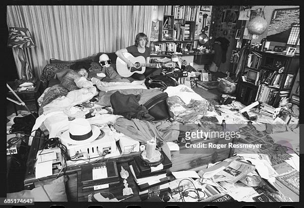 Paul Kantner sits up in bed and plays an acoustic guitar, his daughter China beside him, in a rather messy bedroom.
