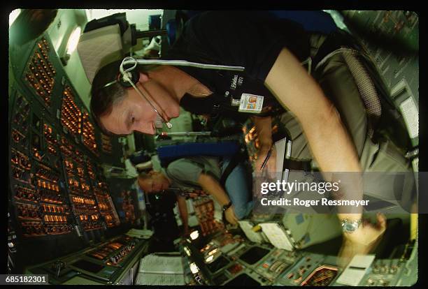Commander Dick Covey and pilot Ken Bowersox sit at the controls of a space shuttle flight simulator. They are rehearsing aborted shuttle launches.