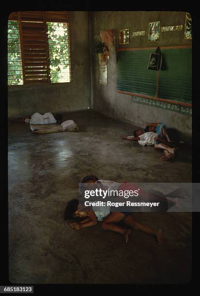 Children sleep on the floor of a classroom after leaving Volcano Island. Evacuees are fleeing their homes after an eruption warning. Philippines. |...