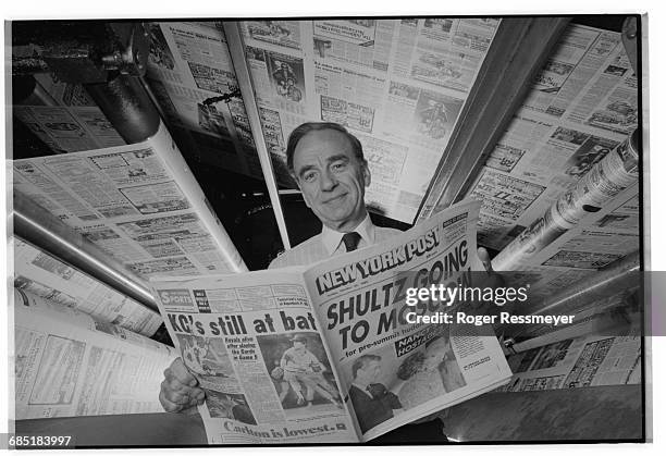 Publishing magnate Rupert Murdoch at the printing presses of the New York Post. He is reading a copy of the newspaper, whose headline declares...