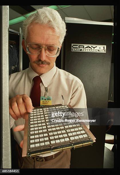 Computer engineer looks at a circuit board for a Cray supercomputer.