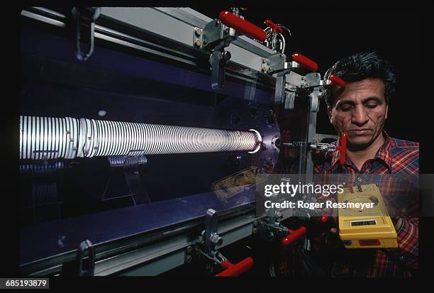 John Leija studies the MIMI electron accelerator at Sandia Labs with a current meter. The accelerator is being used to test a way of efficiently...