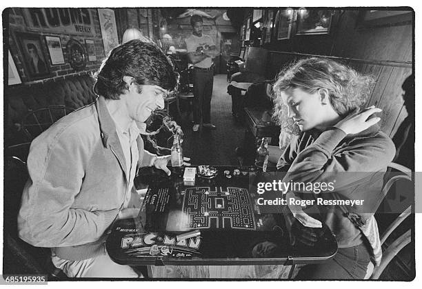 Author David Sudnow and a woman play a table top Pac-Man game at a Berkeley restaurant.