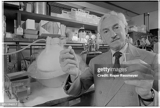 Scientist Dr. Alejandro Zaffaroni holds two of his contraceptive inventions; a birth-control patch, and a "T"-shaped disk-secretion device.