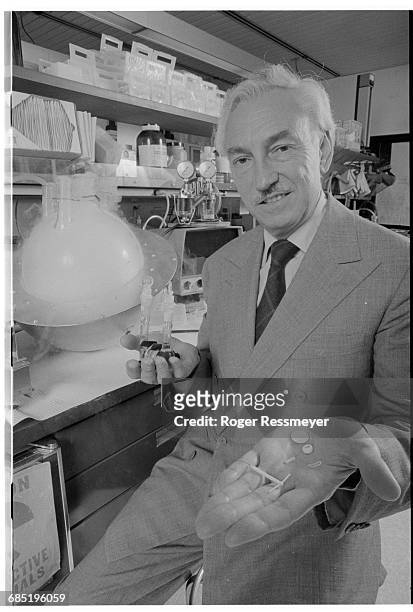 Dr. Alejandro Zaffaroni holds two of his contraceptive inventions; a birth-control patch, and a "T"-shaped disk-secretion device.