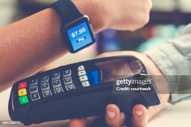 paying with a smart watch. - smartwatch pay stock pictures, royalty-free photos & images