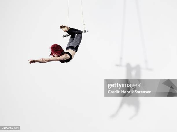 circus artist in trapeze - trapeze stock-fotos und bilder