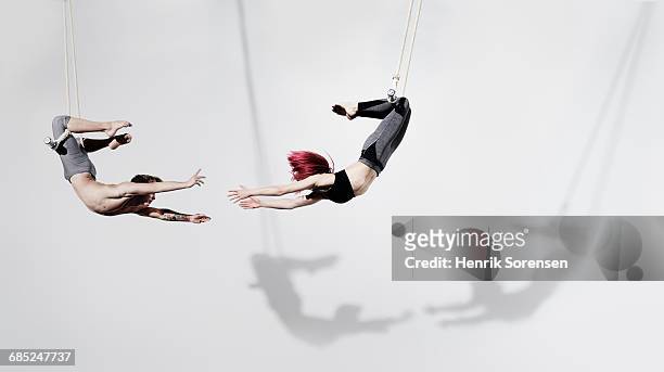 circus artists in trapeze - partnership teamwork stock-fotos und bilder