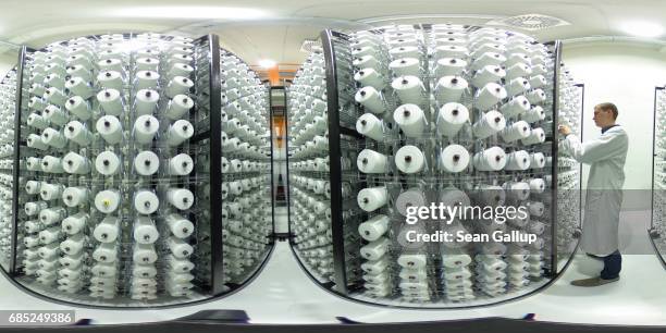 Trainee from the Fraunhofer Institute for scientific research, at the request of present media, checks spools of plastic fibre at a test loom for...