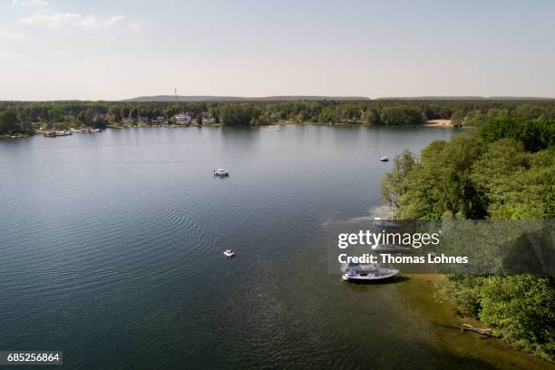 People anchore with their boots at the 'Liebesinsel' in the lake 'Werlesee' in Brandenburg state on May 19, 2017 in Fangschleuse near Erkner,...