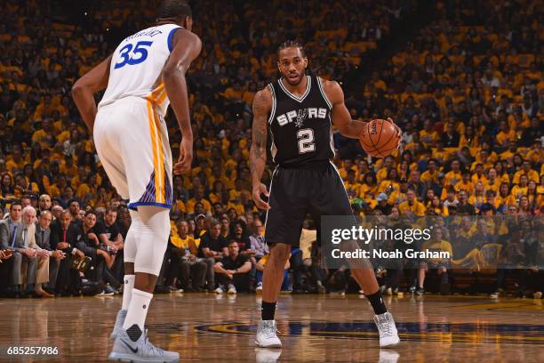 Kawhi Leonard of the San Antonio Spurs dribbles the ball while guarded by Kevin Durant of the Golden State Warriors in Game One of the Western...